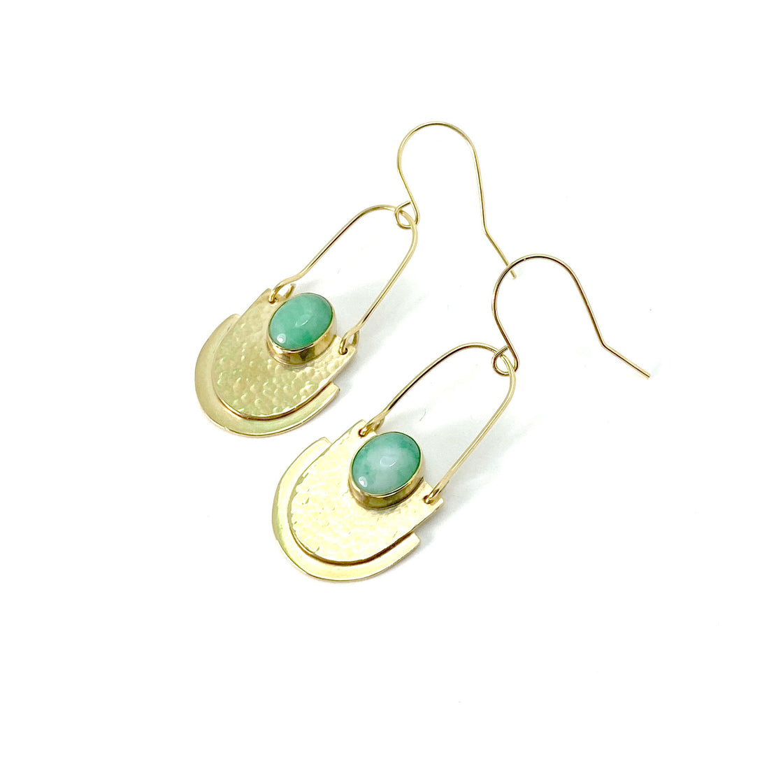 Gold colour brass earrings with a tiered, u-shaped pendant hanging from a wire loop with wire ear hooks. Centered on the pendant is a light-green oval stone.