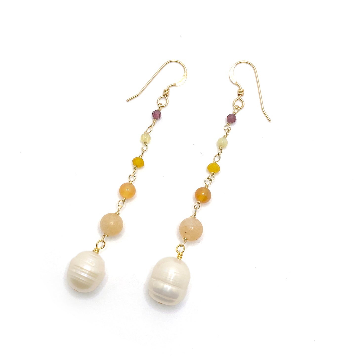 14k gold-filled hook earrings in the hues of a warm sunset. Beads connected by delicate wire wraps and increasing in size as they go down. Starting at the top with a tiny faceted garnet, a round yellow opal, a faceted dyed yellow quartz, a round orange agate, a round pale orange carnelian, and an oblong freshwater pearl.