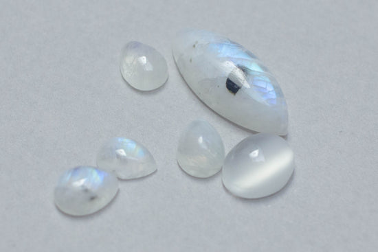 small white moonstones in teardrop and marquis shapes. Some flash blue where the light hits them.